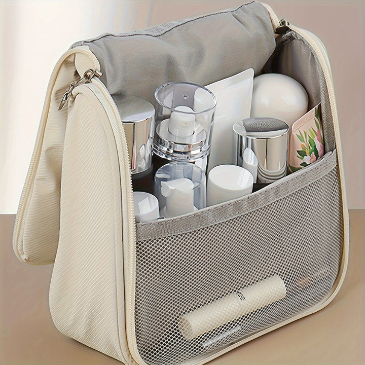 Beauty case da viaggio beige aperto, con scomparti organizzati contenenti flaconi cosmetici e accessori per la cura personale.