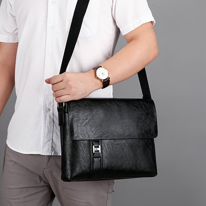 Uomo con camicia bianca indossa borsa a tracolla in pelle nera, elegante e moderna, ideale per lavoro e ufficio. Accessorio moda maschile.