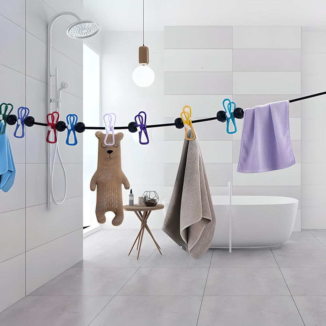 Bagno moderno con vasca freestanding, asciugamani colorati appesi, orsacchiotto di stoffa, doccia a pioggia e lampada a sospensione.