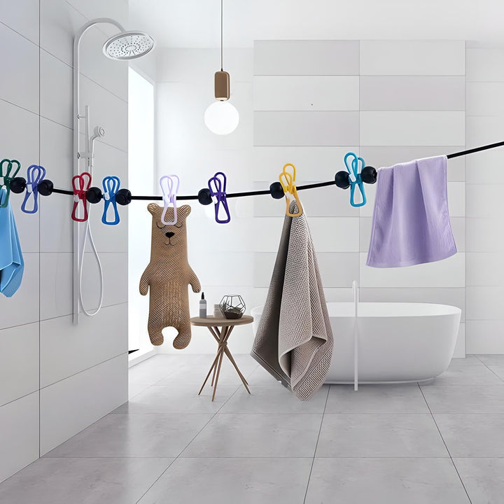 Bagno moderno con vasca freestanding, asciugamani colorati appesi, orsacchiotto di stoffa, doccia a pioggia e lampada a sospensione.