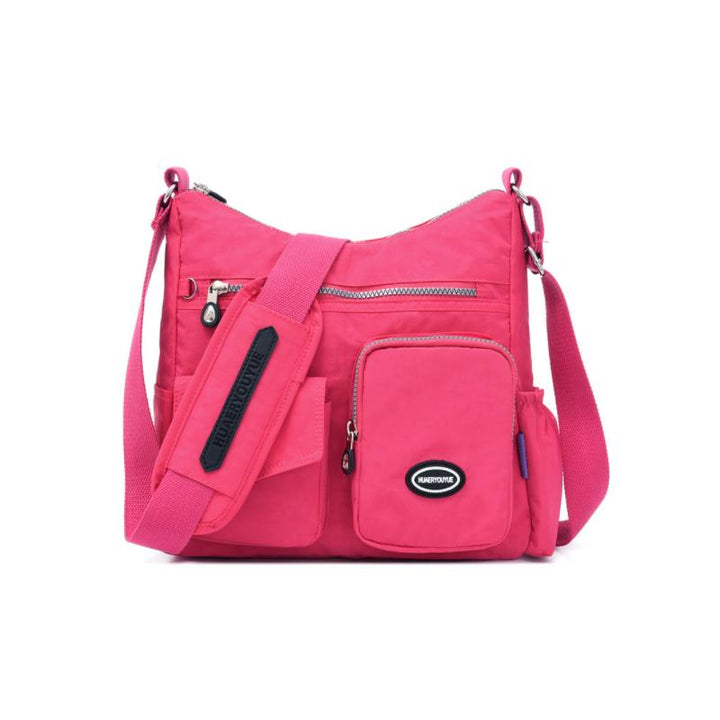 Borsa a tracolla rosa con tasche multiple, cerniere e logo. Design pratico e moderno, ideale per donna. Accessorio moda versatile e funzionale.