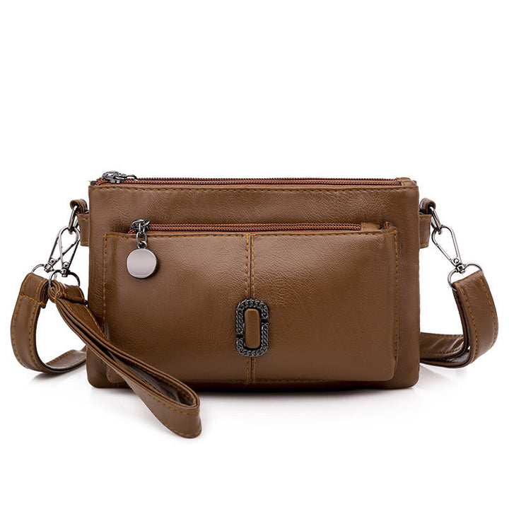 Borsa a tracolla in pelle marrone con tasche multiple e cerniere, design elegante e pratico, ideale per donna, accessorio moda versatile.