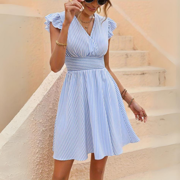 Abito estivo a righe blu e bianche, scollo a V, maniche a volant, indossato da donna. Perfetto per moda estiva e look casual elegante.
