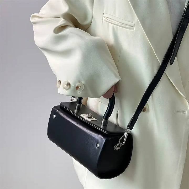 Giacca bianca elegante con borsa a tracolla nera in pelle, design moderno, chiusura metallica, moda uomo, accessorio di tendenza.