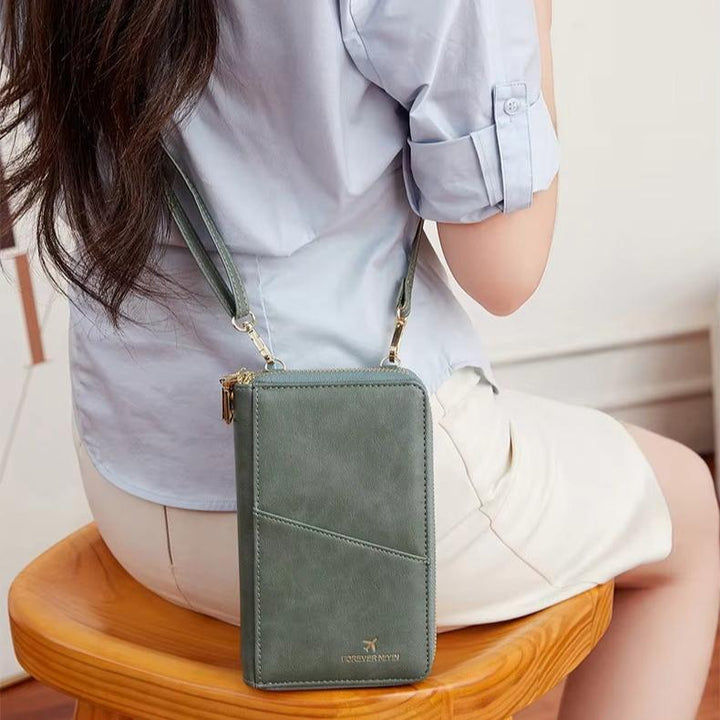 Borsa a tracolla verde in pelle, design elegante, indossata da donna seduta. Accessorio moda femminile, ideale per uso quotidiano.