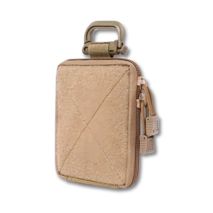 Custodia tattica beige con zip, moschettone e tasche multiple. Ideale per accessori outdoor, campeggio e escursionismo. Resistente e compatta.