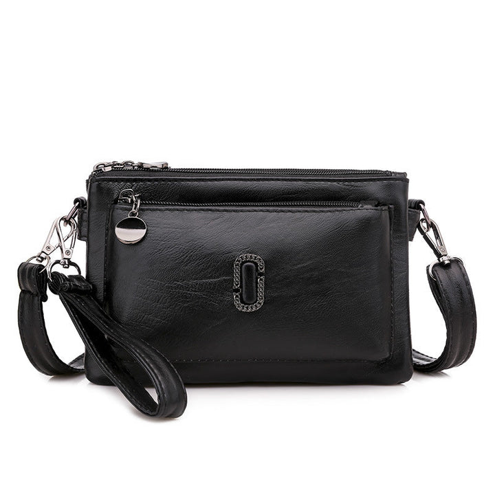 Borsa a tracolla in pelle nera con cerniera, tasca frontale, logo decorativo e cinturino regolabile. Elegante e versatile per ogni occasione.