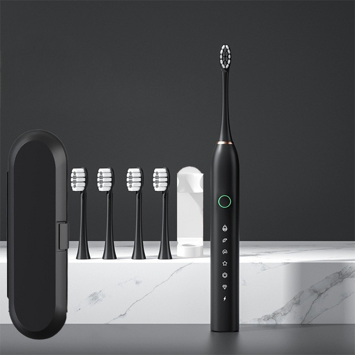 Spazzolino elettrico nero con custodia e cinque testine di ricambio su sfondo marmo. Design moderno, ideale per igiene orale avanzata.