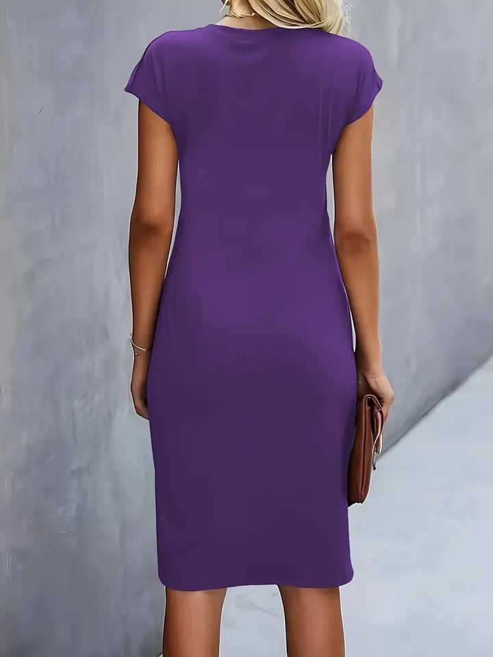 Abito viola donna, maniche corte, lunghezza al ginocchio, stile casual, sfondo grigio. Perfetto per moda estiva e look quotidiano.