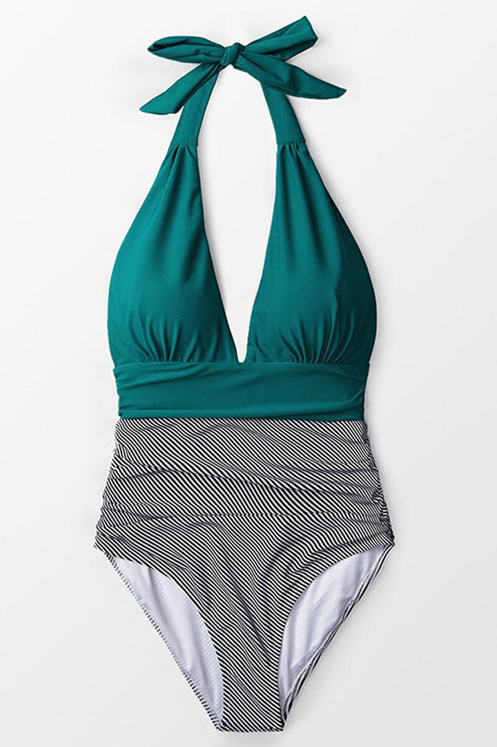 Costume intero donna verde con scollo a V e righe bianche e nere, design elegante, perfetto per la spiaggia o la piscina.