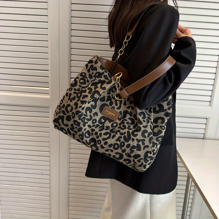 Donna con borsa a tracolla leopardata, manici marroni, catena dorata. Moda femminile, accessori eleganti, stile casual chic.
