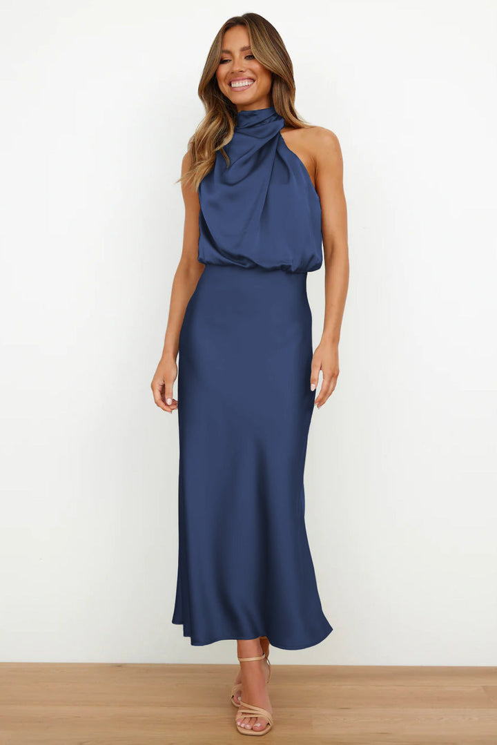 Abito lungo blu elegante con scollo all'americana, indossato da una donna sorridente. Perfetto per eventi formali e serate speciali.