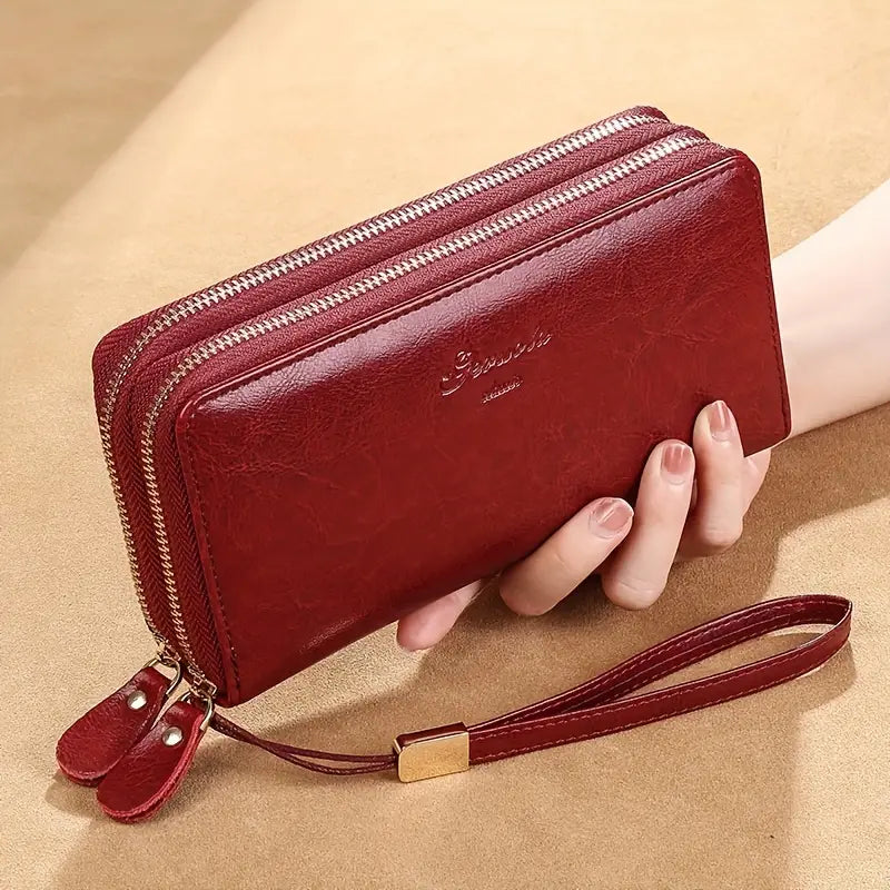 Portafoglio donna in pelle rossa con doppia cerniera, cinturino da polso e dettagli dorati. Elegante accessorio moda, ideale per organizzare carte e contanti.