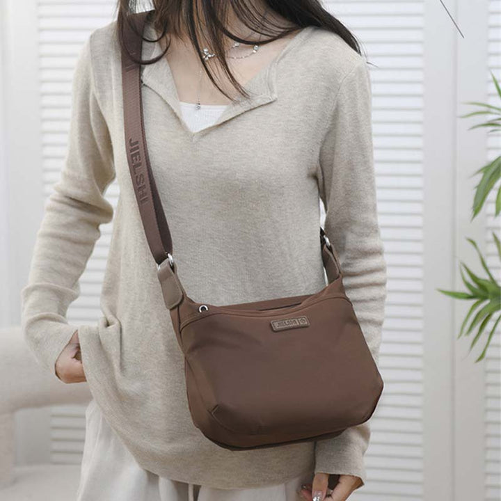 Borsa a tracolla marrone da donna, design casual, tessuto resistente, ideale per uso quotidiano. Accessorio moda versatile e pratico.