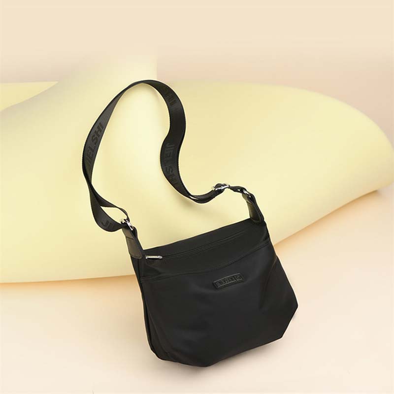 Borsa a tracolla nera in nylon, design elegante e moderno, ideale per donna, con cinghia regolabile. Accessorio moda versatile e pratico.