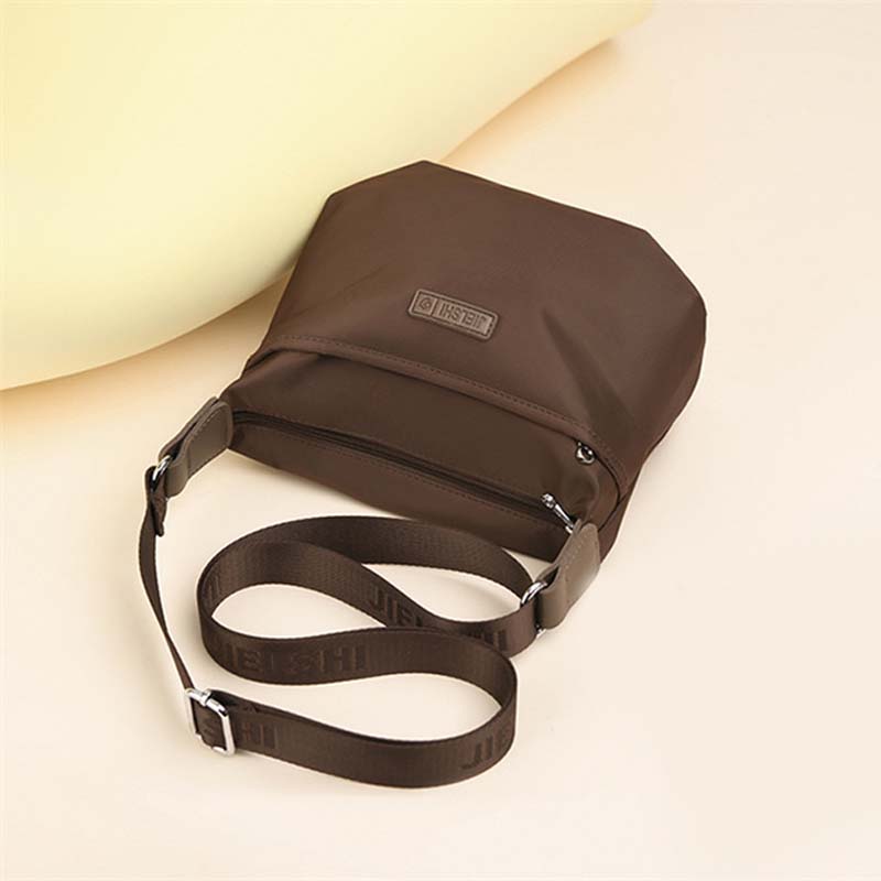 Borsa a tracolla marrone in nylon, design minimalista, con cinghia regolabile e chiusura a zip. Accessorio moda unisex, pratico e leggero.