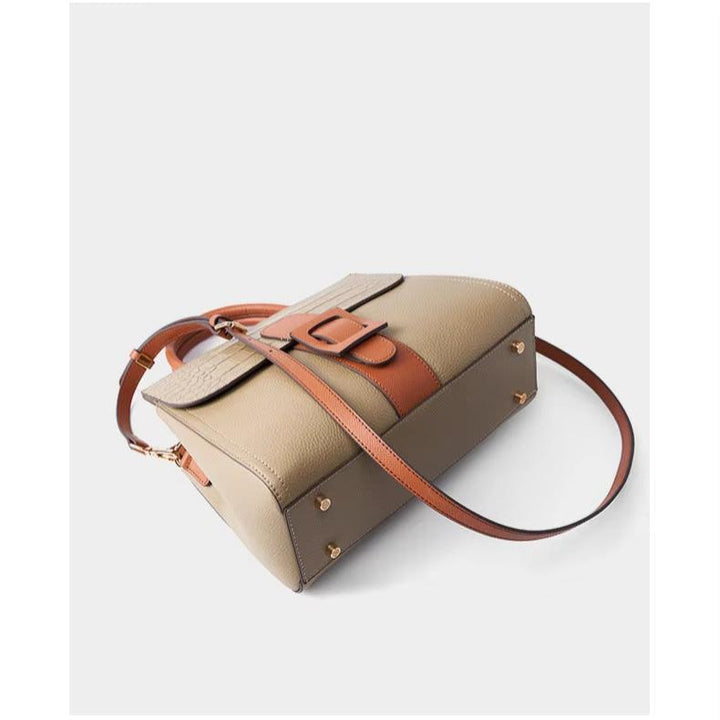 Borsa a tracolla in pelle beige e marrone con fibbia decorativa, design elegante e moderno, accessorio moda donna, perfetta per ogni occasione.