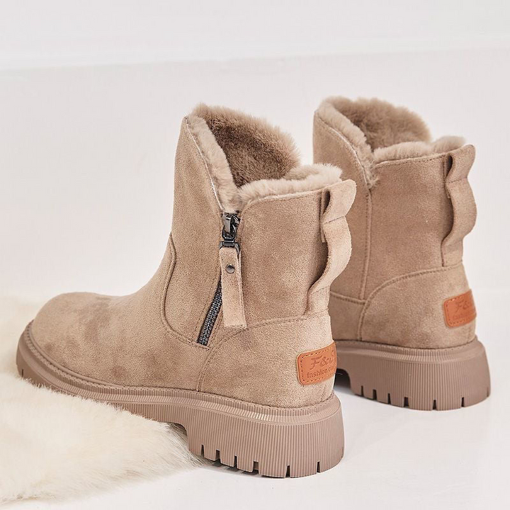 Stivali invernali beige da donna in pelle scamosciata con fodera in pelliccia sintetica, suola antiscivolo e chiusura a zip laterale.