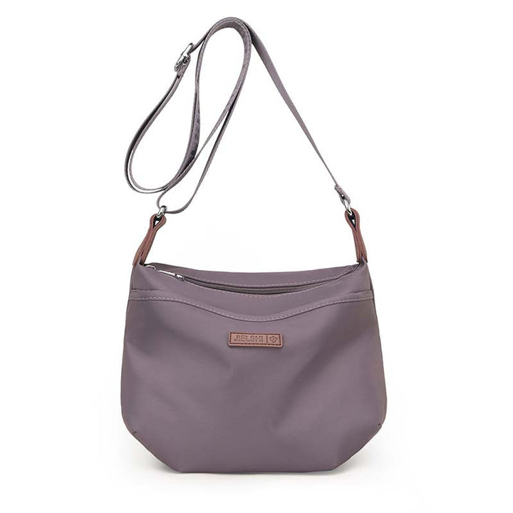 Borsa a tracolla grigia in tessuto impermeabile, design elegante e minimalista, con cerniera e tracolla regolabile. Accessorio moda donna.