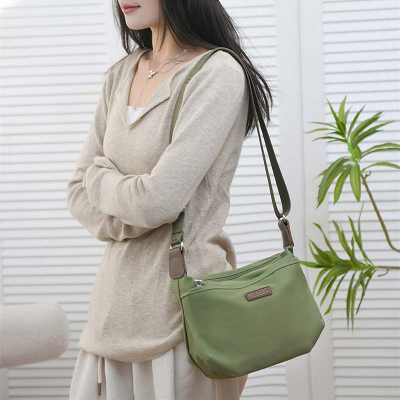 Donna con borsa a tracolla verde, design casual, indossa maglione beige. Accessorio moda femminile, stile quotidiano, perfetto per shopping.