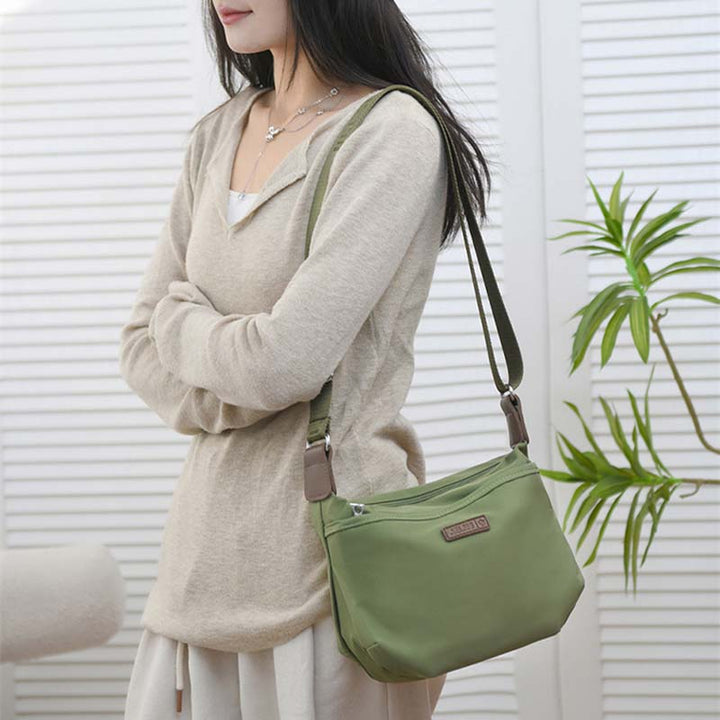 Donna con borsa a tracolla verde, design casual, indossa maglione beige. Accessorio moda femminile, stile quotidiano, perfetto per shopping.