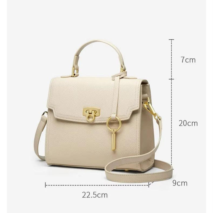 Borsa a tracolla beige in pelle, dimensioni 22.5x9x20 cm, con manico superiore, chiusura a scatto dorata e ciondolo chiave. Elegante e versatile.