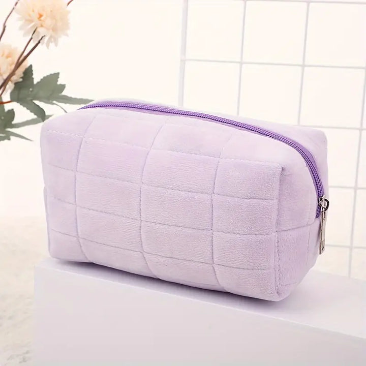 Astuccio cosmetico viola in velluto, design trapuntato, chiusura con cerniera, ideale per trucco e accessori, elegante e pratico.
