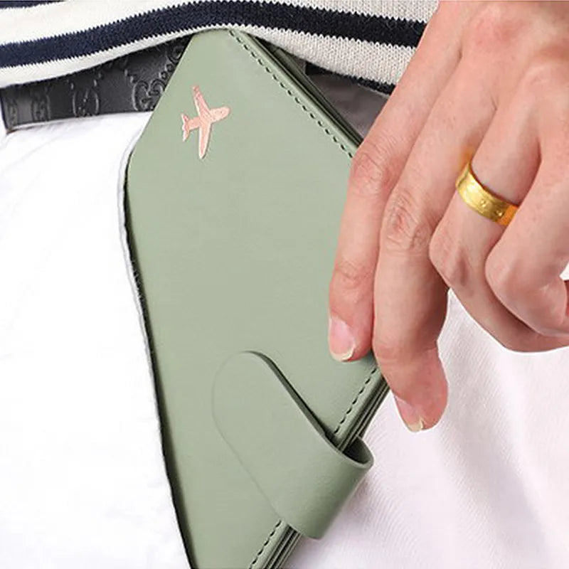 Custodia verde per smartphone con logo aereo, chiusura magnetica, in mano a persona con anello dorato. Accessorio elegante e funzionale.