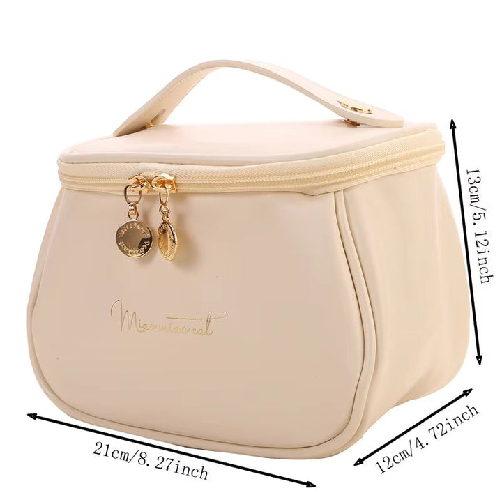 Borsa cosmetica beige con cerniera dorata, manico superiore e dimensioni 21x12x13 cm. Elegante e pratica per viaggi e organizzazione trucco.