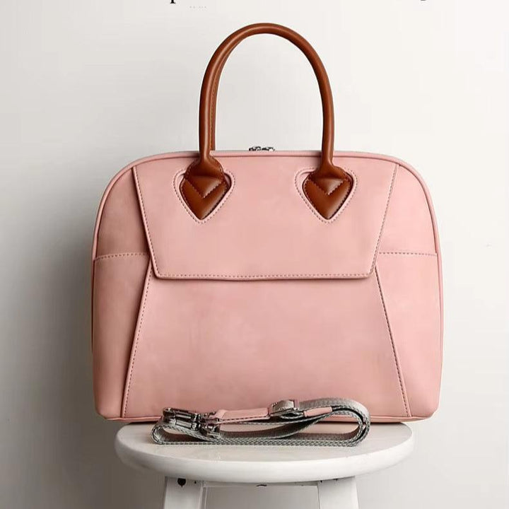 Borsa a mano rosa in pelle con manici marroni, design elegante, perfetta per moda femminile, accessorio di tendenza, su sgabello bianco.