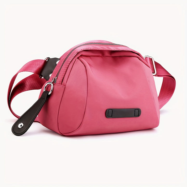 Borsa a tracolla rosa in tessuto, design moderno, con cerniera e dettagli in pelle nera. Accessorio moda donna, elegante e pratico.