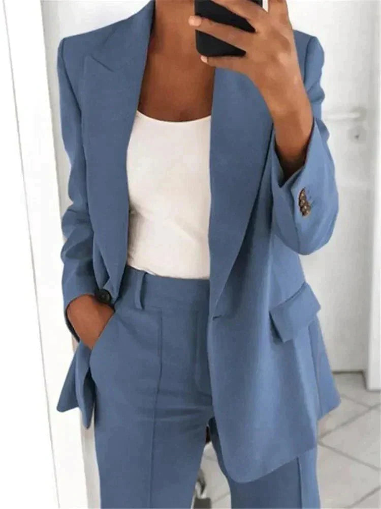 Completo donna elegante blu, giacca e pantaloni abbinati, indossato con top bianco. Moda femminile, abbigliamento formale, stile business casual.