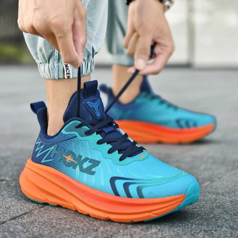 Scarpe da corsa blu e arancioni su strada, design moderno, suola ammortizzata, lacci neri, ideali per sport e attività all'aperto.