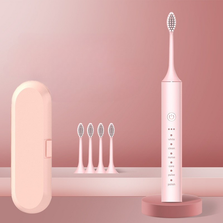 Spazzolino elettrico rosa con custodia, quattro testine di ricambio, base di ricarica. Design elegante, ideale per igiene orale avanzata.