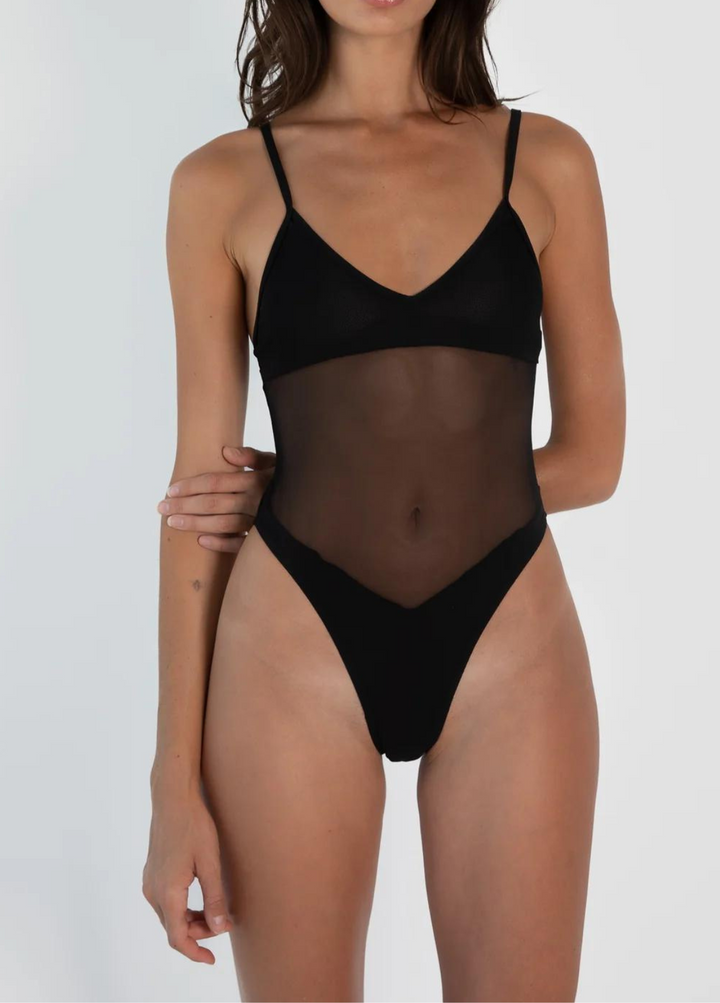Donna in body nero trasparente, spalline sottili, design elegante. Intimo femminile moderno, moda donna, abbigliamento sexy.