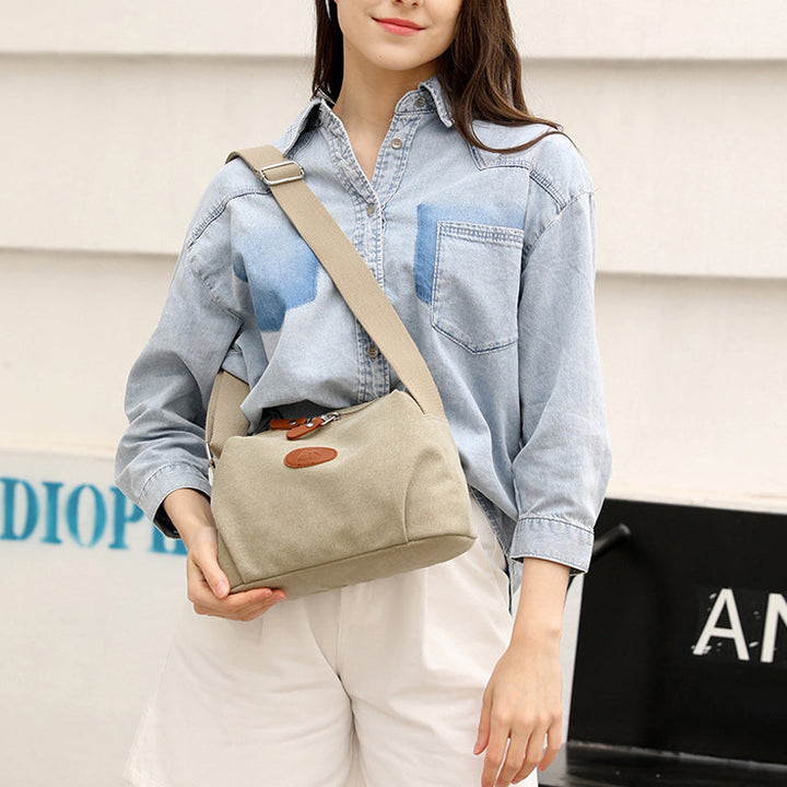 Donna con camicia di jeans e borsa a tracolla beige, stile casual. Moda femminile, accessori eleganti, abbigliamento estivo.