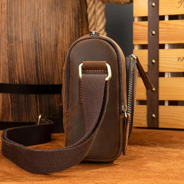 Borsa a tracolla in pelle marrone vintage, design compatto, cerniera robusta, ideale per uomo, accessorio moda elegante e funzionale.