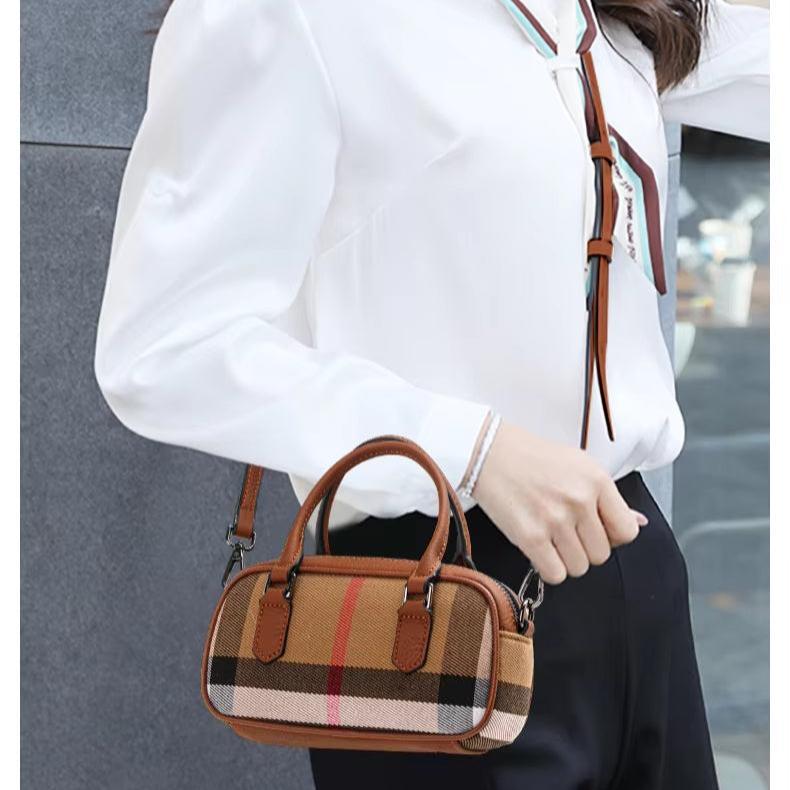 Donna con camicia bianca indossa borsa a tracolla in pelle marrone con motivo a quadri. Accessorio moda elegante, perfetto per look casual e formali.