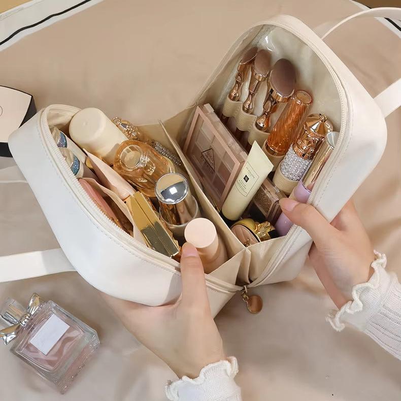 Borsa cosmetica bianca aperta con trucchi e accessori, tra cui rossetti, pennelli e profumo. Organizzatore da viaggio elegante e funzionale.