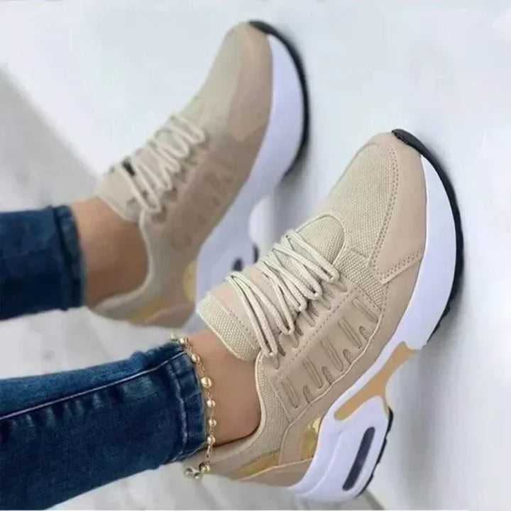 Scarpe da ginnastica beige da donna, suola bianca, dettagli dorati, indossate con jeans. Sneakers moda casual, comode e trendy.
