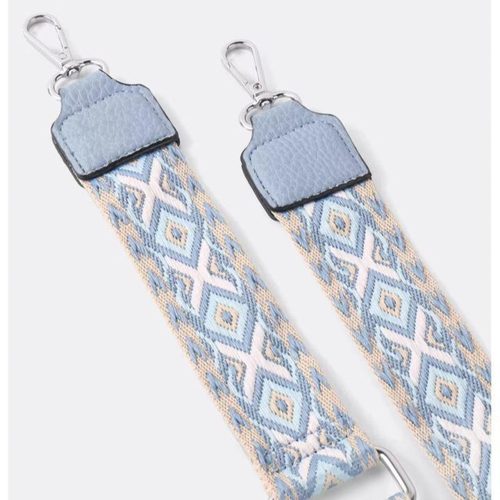 Cinturino borsa regolabile in tessuto jacquard azzurro con motivo geometrico, ganci metallici argentati. Accessorio moda elegante e versatile.