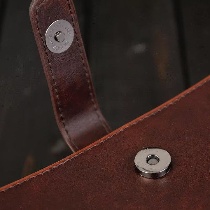 Borsa in pelle marrone con chiusura magnetica in metallo, dettaglio elegante e resistente, accessorio moda di alta qualità.