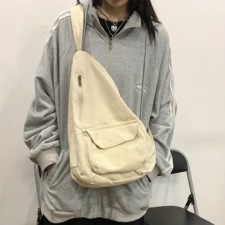 Donna con felpa grigia oversize e borsa a tracolla beige. Stile casual, moda urbana, abbigliamento comodo. Accessorio pratico e versatile.