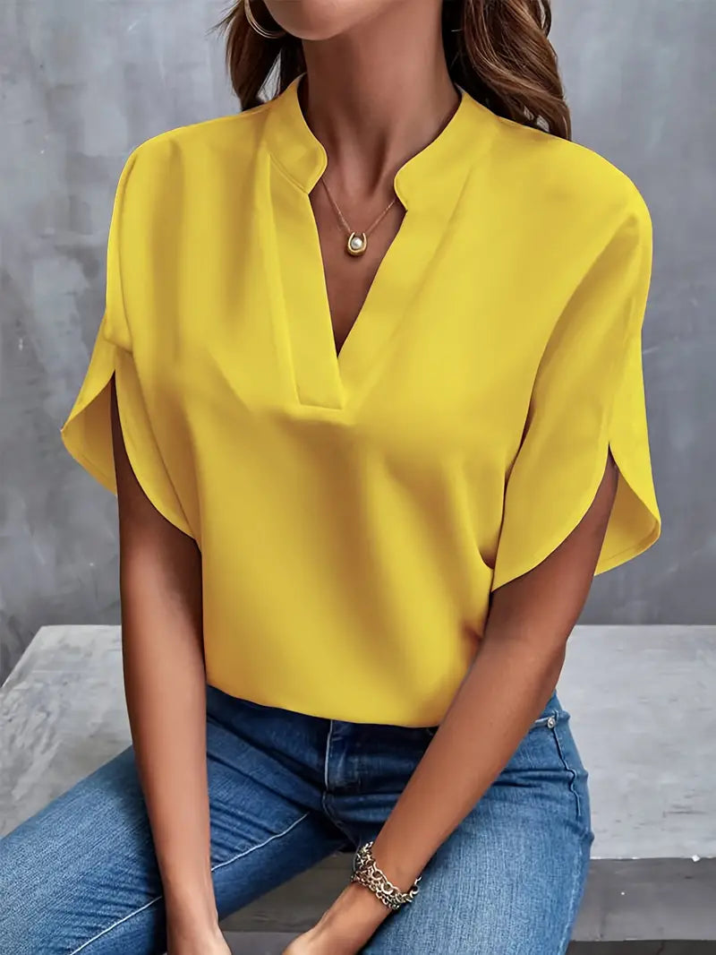Blusa gialla elegante con scollo a V, maniche corte, indossata con jeans. Moda donna casual chic, abbigliamento estivo, tendenze 2023.