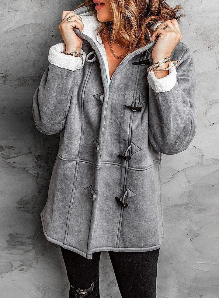 Cappotto donna invernale grigio, stile montgomery, con fodera in pelliccia sintetica bianca e chiusura a alamari. Elegante e caldo per l'inverno.
