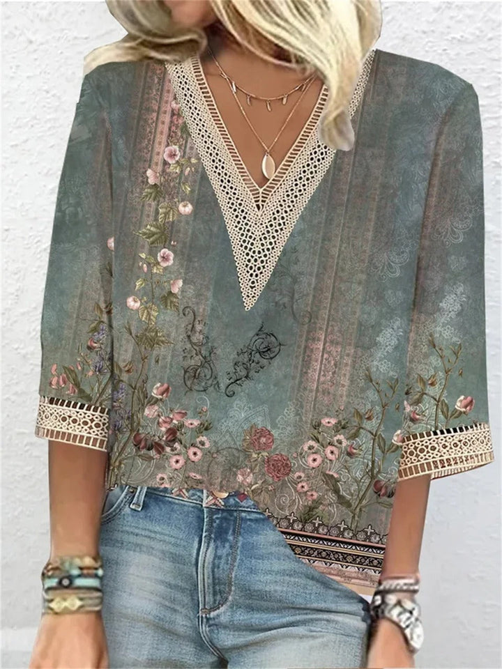 Blusa donna boho chic con scollo a V, maniche a 3/4, motivo floreale vintage, dettagli in pizzo, abbinata a jeans. Stile casual elegante.