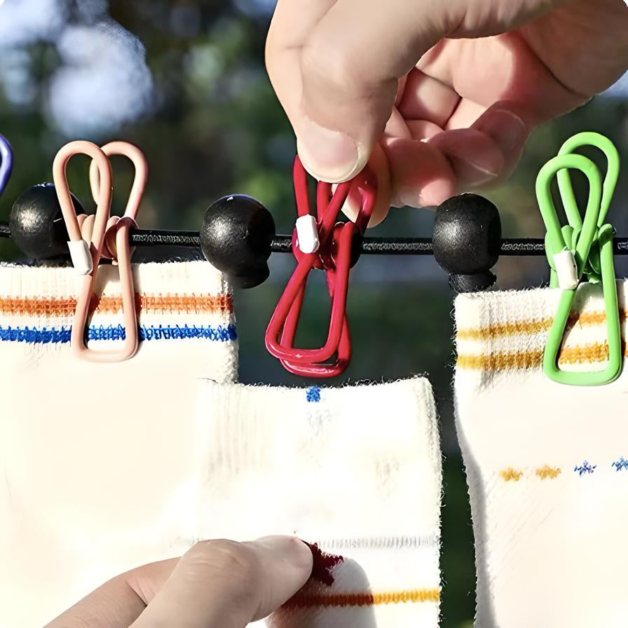 Mani che appendono calzini bianchi con mollette colorate su uno stendibiancheria all'aperto. Accessori lavanderia, asciugatura efficiente.