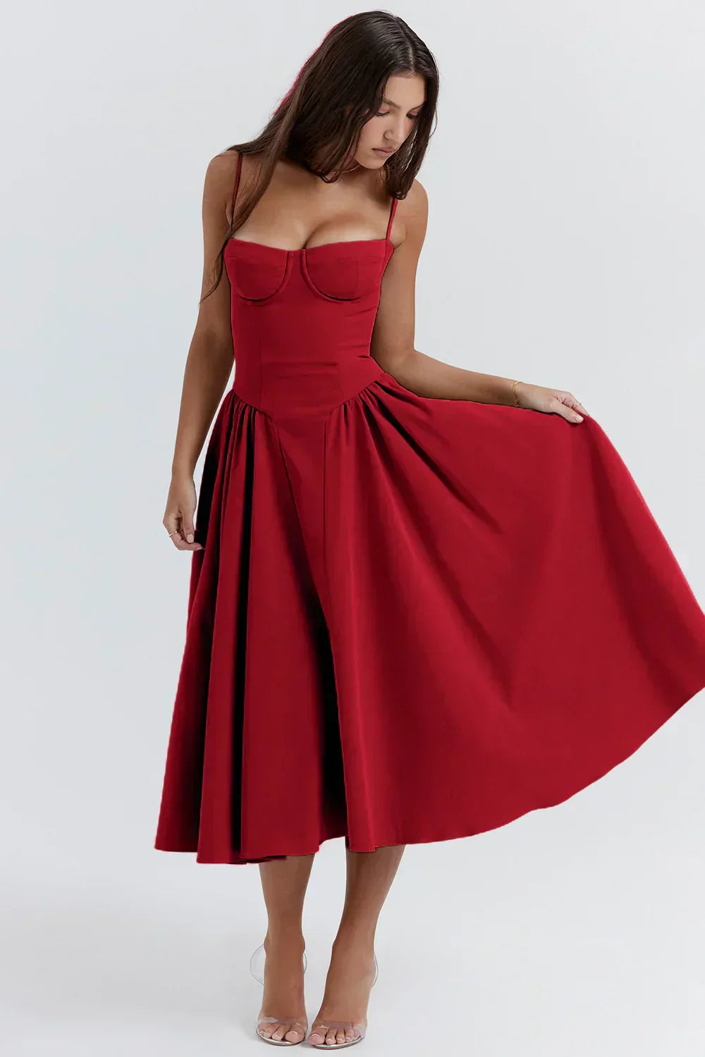 Donna con abito rosso elegante, scollatura a cuore, spalline sottili, gonna ampia. Moda femminile, abbigliamento da sera, stile sofisticato.