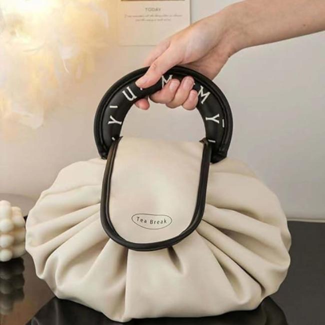 Borsa a mano elegante in pelle bianca con manico nero decorato, design moderno e chic, perfetta per moda femminile e accessori di lusso.