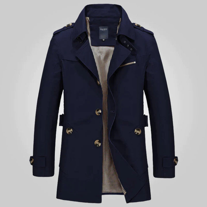 Cappotto trench uomo blu scuro, doppio petto, con cintura e bottoni, elegante e moderno, ideale per autunno e inverno.